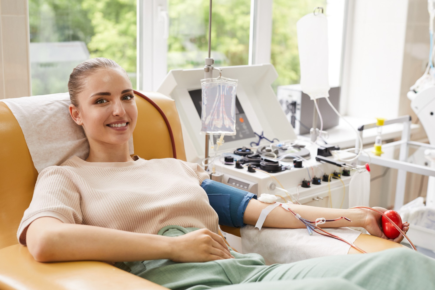 portrait-young-woman-smiling-camera-while-lying-couch-donating-blood-hospital